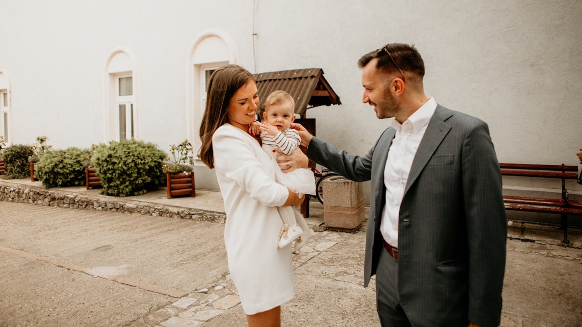 a man and woman holding a baby